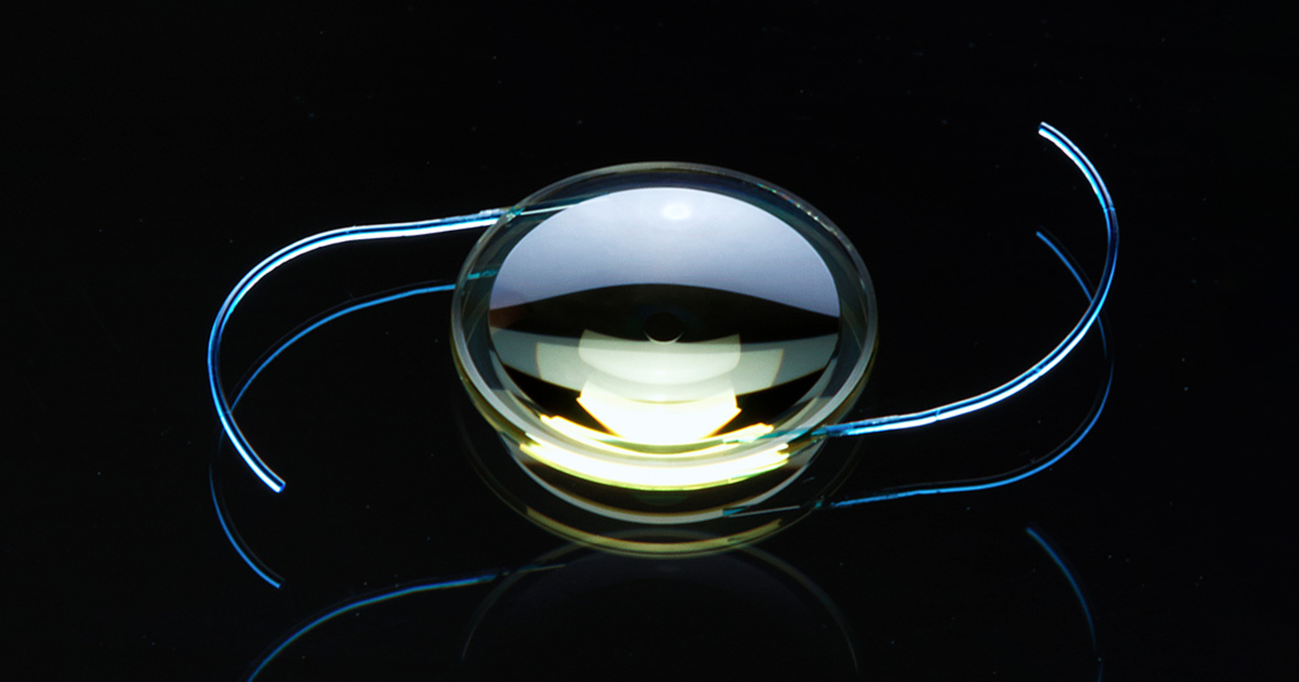 A Light Adjustable Lens with curved haptics shown against a black background.