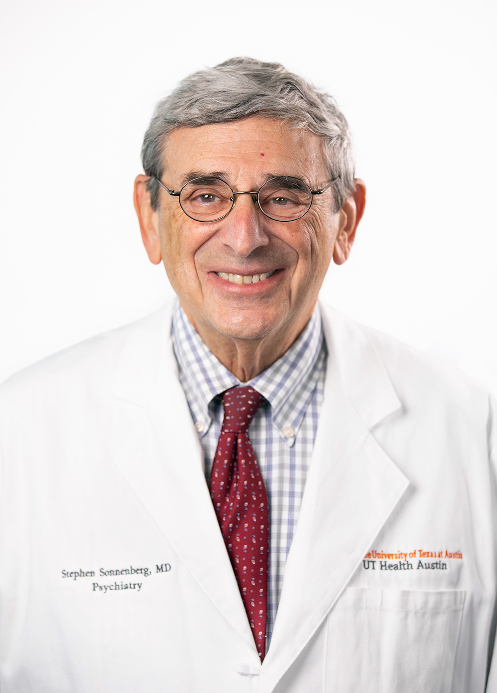 Psychiatrist Stephen Sonnenburg, MD, wearing a white coat and smiling in front of a white backdrop.